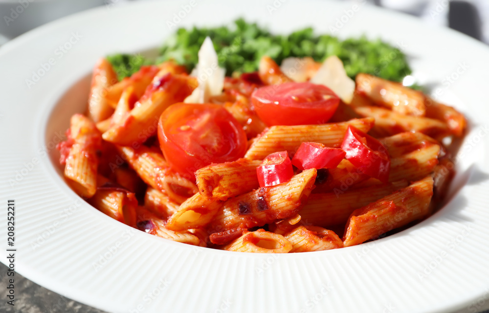Plate with delicious penne pasta and garnish, closeup