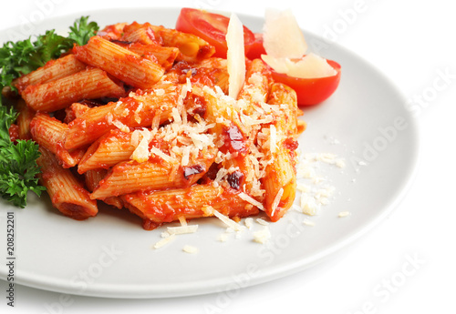 Plate with delicious penne pasta and garnish on white background