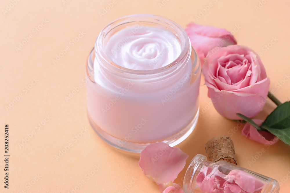 Jar of body cream and flowers on color background Jar of body cream and flowers on color background