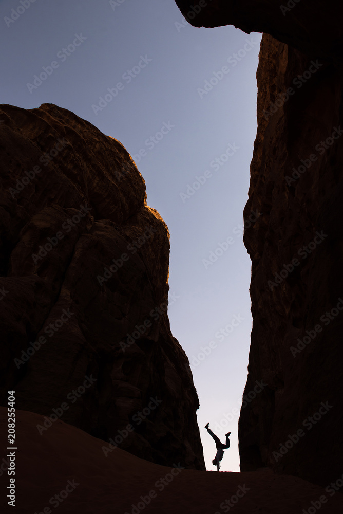 Woman doing a handstand in a narrow canyon