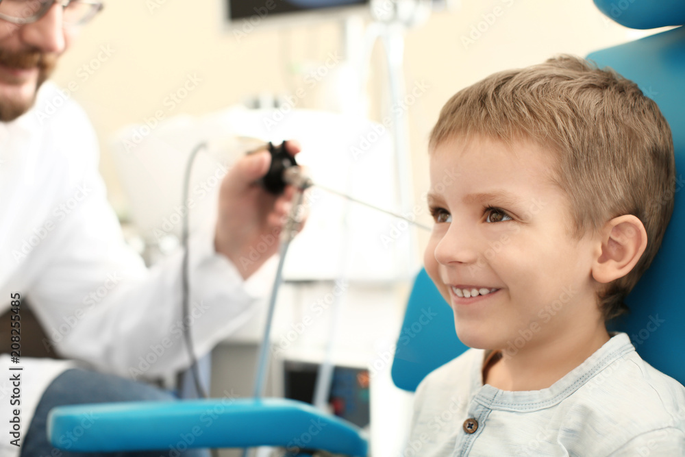 Otolaryngologist examining little boy's ear with ENT telescope in hospital Otolaryngologist examining little boy's ear with ENT telescope in hospital