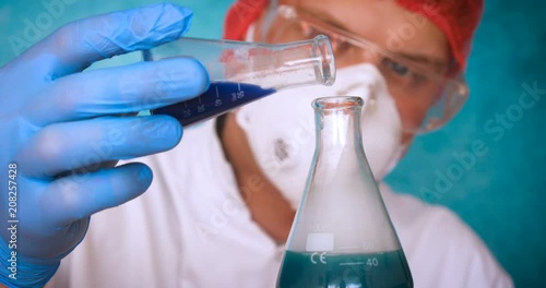 The alchemist, holds the flasks, tests the test tubes with a test of different compositions, in a white coat, a respirator, goggles, rubber white gloves, a green background.