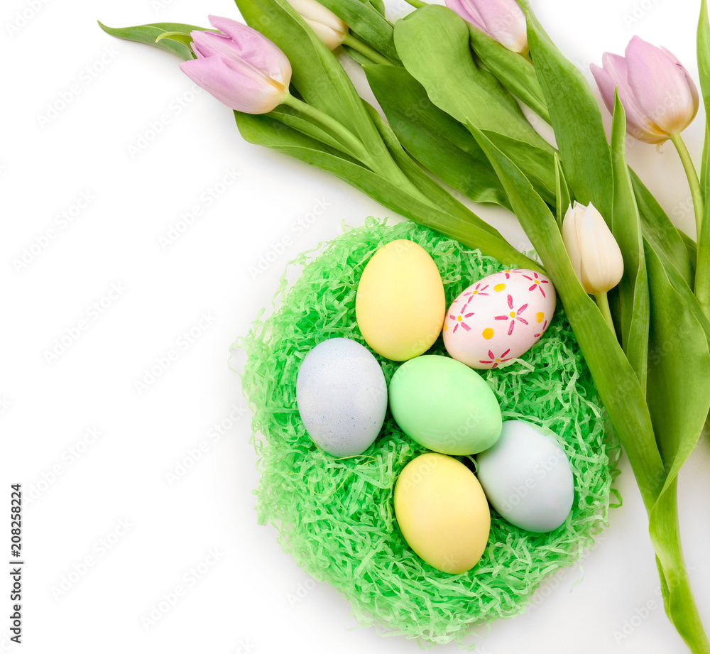 Decorative nest with dyed Easter eggs and spring flowers on white background Decorative nest with dyed Easter eggs and spring flowers on white background