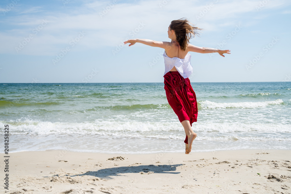 Beautiful girl in red dress by the sea. Beautiful girl in red dress by the sea.