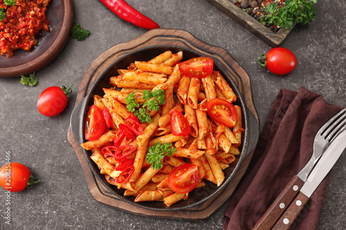 Composition with tasty penne pasta on grey background