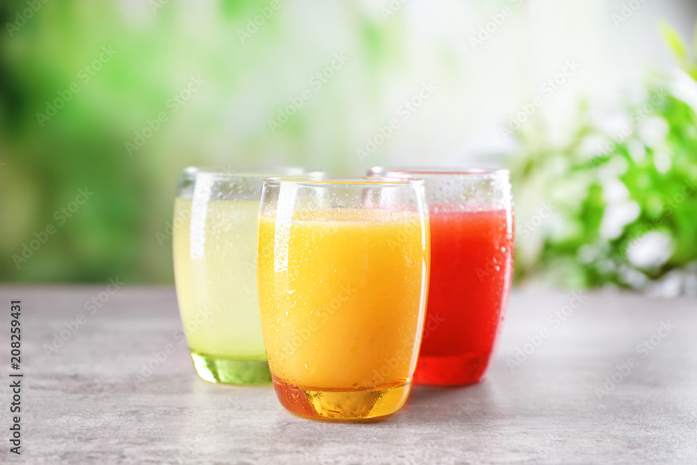 Fototapeta premium Glasses with different citrus juices on table