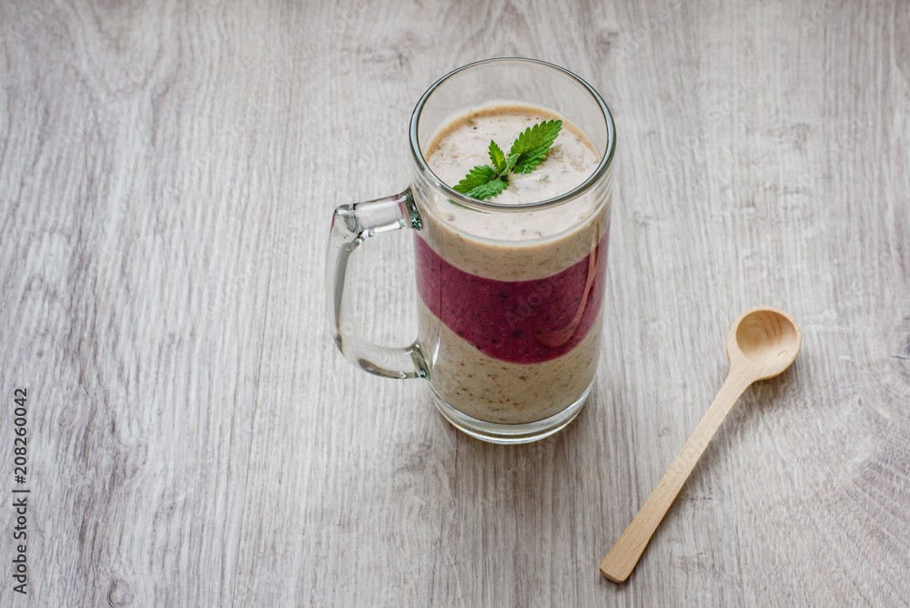 Healthy and healthy food smoothies of fresh milk, strawberries, berries, ice cream and bananas in a glass cup on a wooden background. Healthy and healthy food smoothies of fresh milk, strawberries, berries, ice cream and bananas in a glass cup on a wooden background.