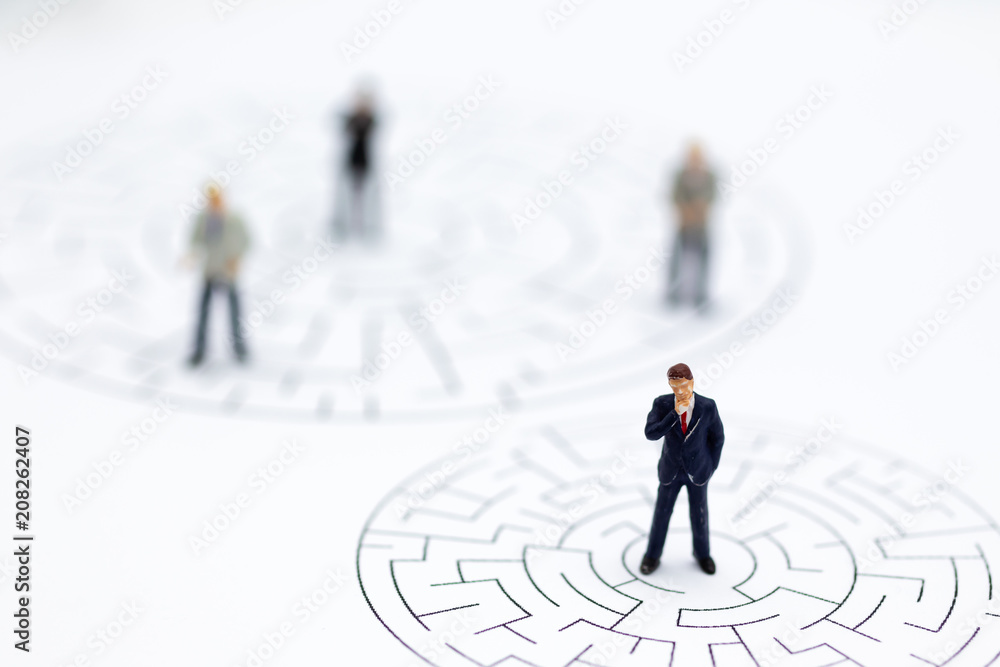 Miniature people : Businessmen in the maze. Image use for to solve problems, finding solution and think new idea concept. Miniature people : Businessmen in the maze. Image use for to solve problems, finding solution and think new idea concept.