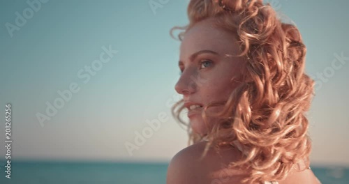 Young redhead hippie woman relaxing at beach at sunset photo