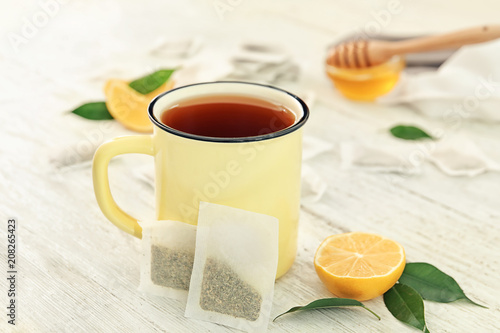 Mug with delicious tea on table