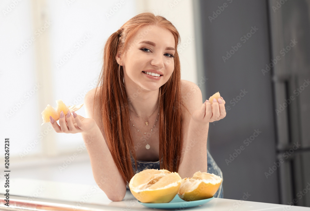 Beautiful young woman with citrus fruit in kitchen Beautiful young woman with citrus fruit in kitchen