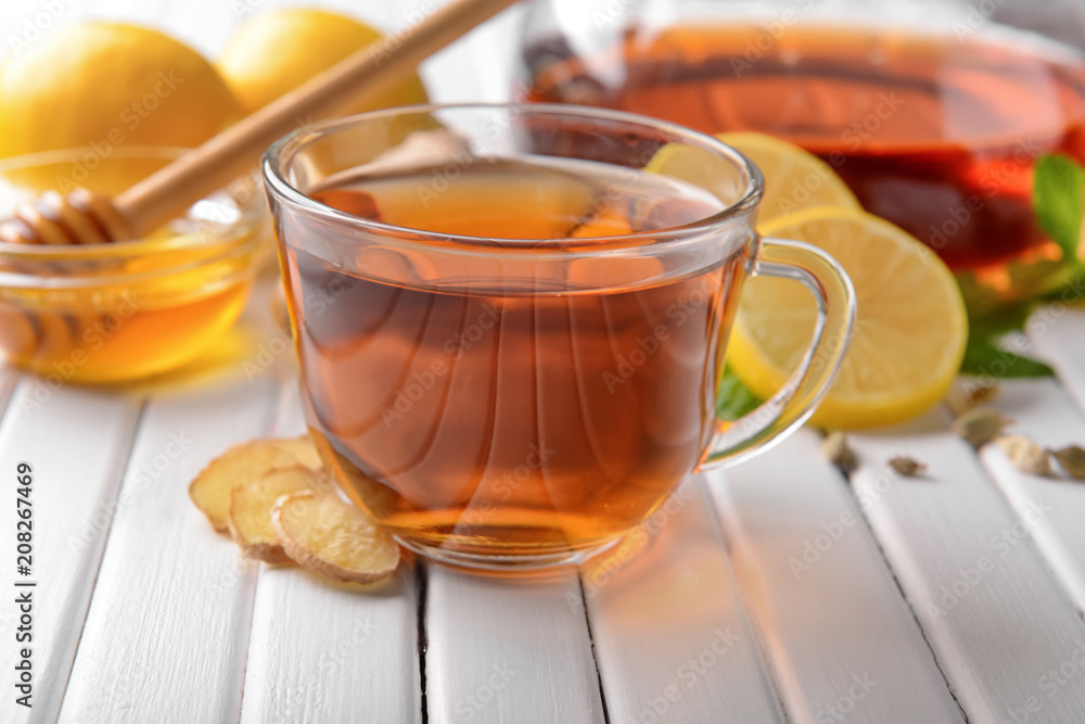 Cup of hot tea with lemon and ginger on wooden table Cup of hot tea with lemon and ginger on wooden table
