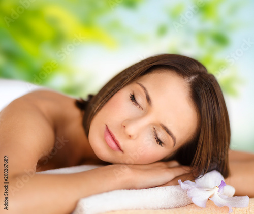 wellness, spa and beauty concept - close up of beautiful woman over green natural background