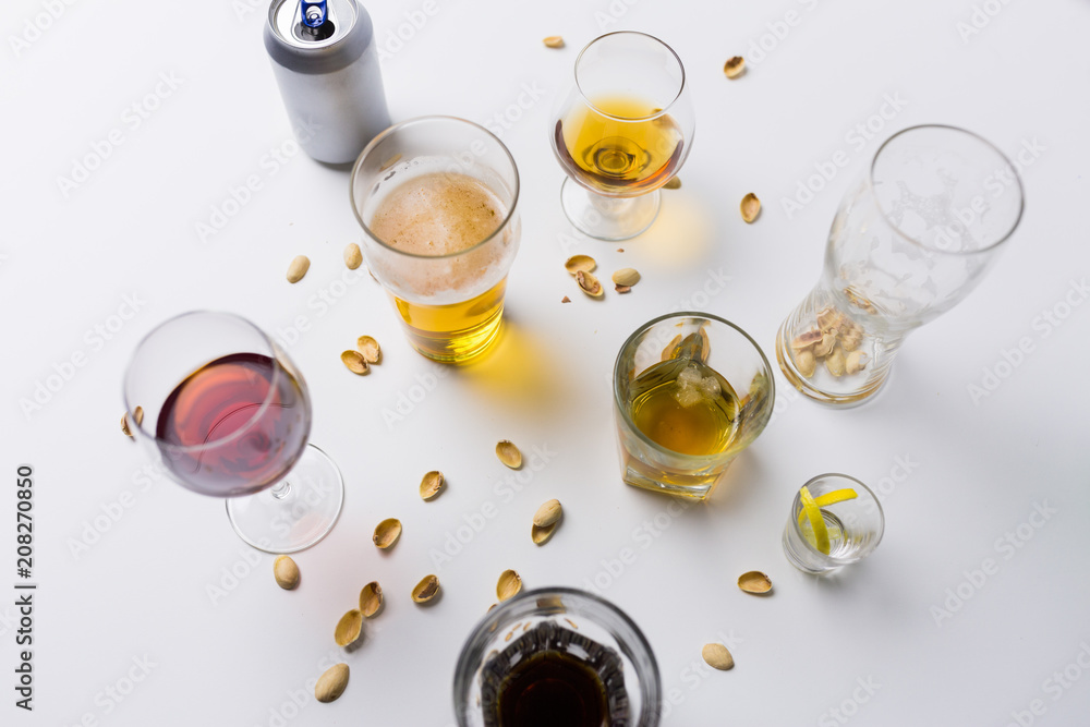 alcohol addiction and drunkenness concept - glasses of different drinks on messy table alcohol addiction and drunkenness concept - glasses of different drinks on messy table