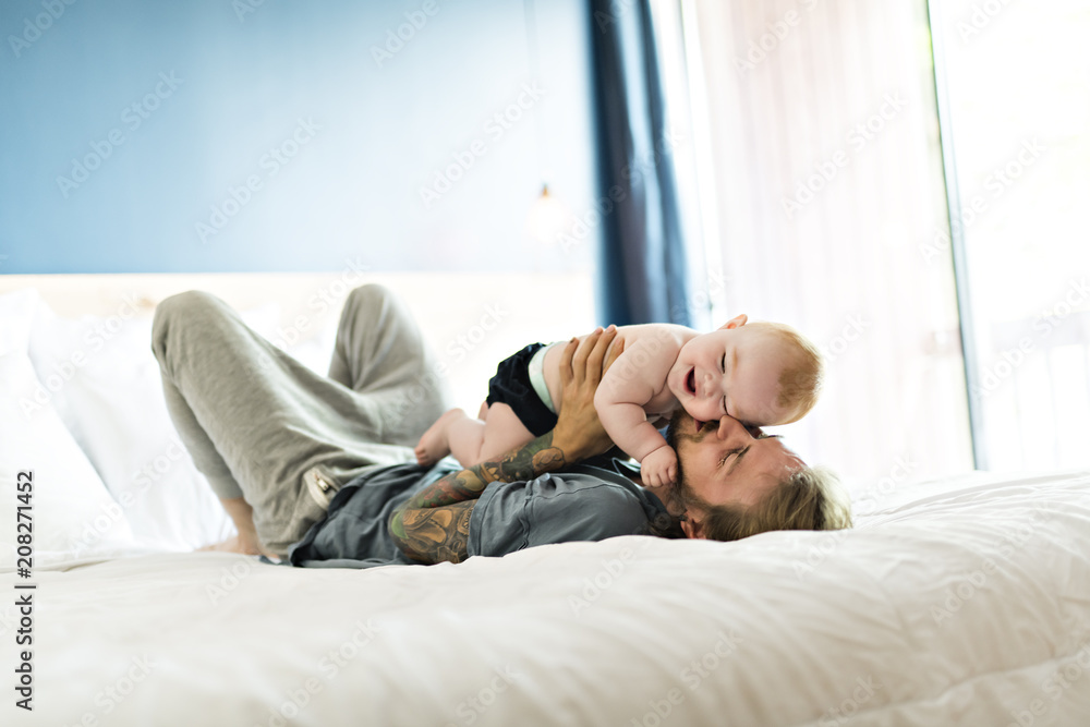 Father playing with adorable baby girl in bedroom Father playing with adorable baby girl in bedroom