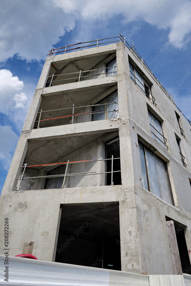 Fototapeta premium Immeubles en cours de construction, béton brut et ciel bleu.