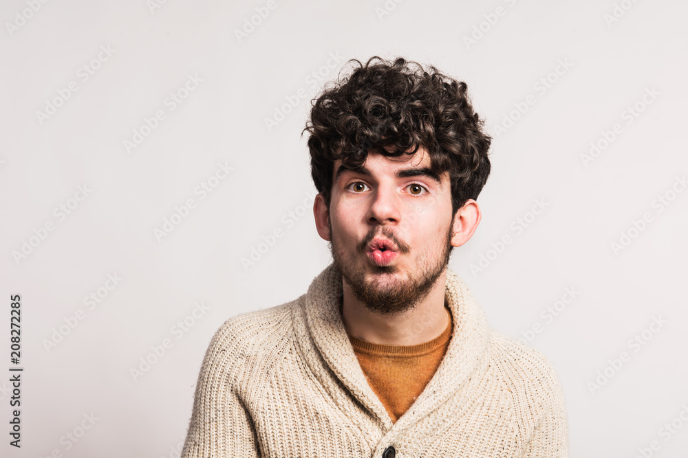 Fototapeta premium Portret młodego mężczyzny w wełnianym swetrze w studio. Skopiuj miejsce.