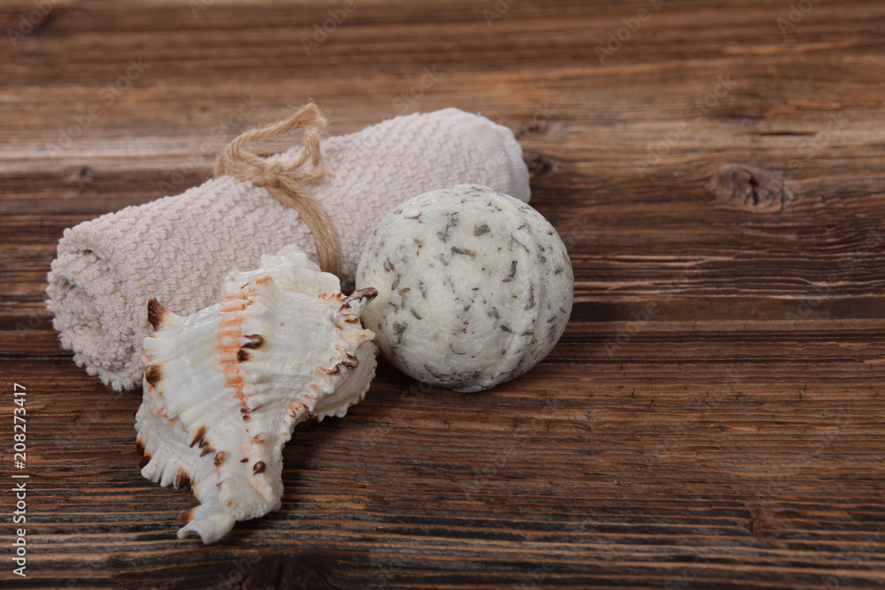 scallop and herbal white bath ball for white towel on a brown background with free space for text scallop and herbal white bath ball for white towel on a brown background with free space for text