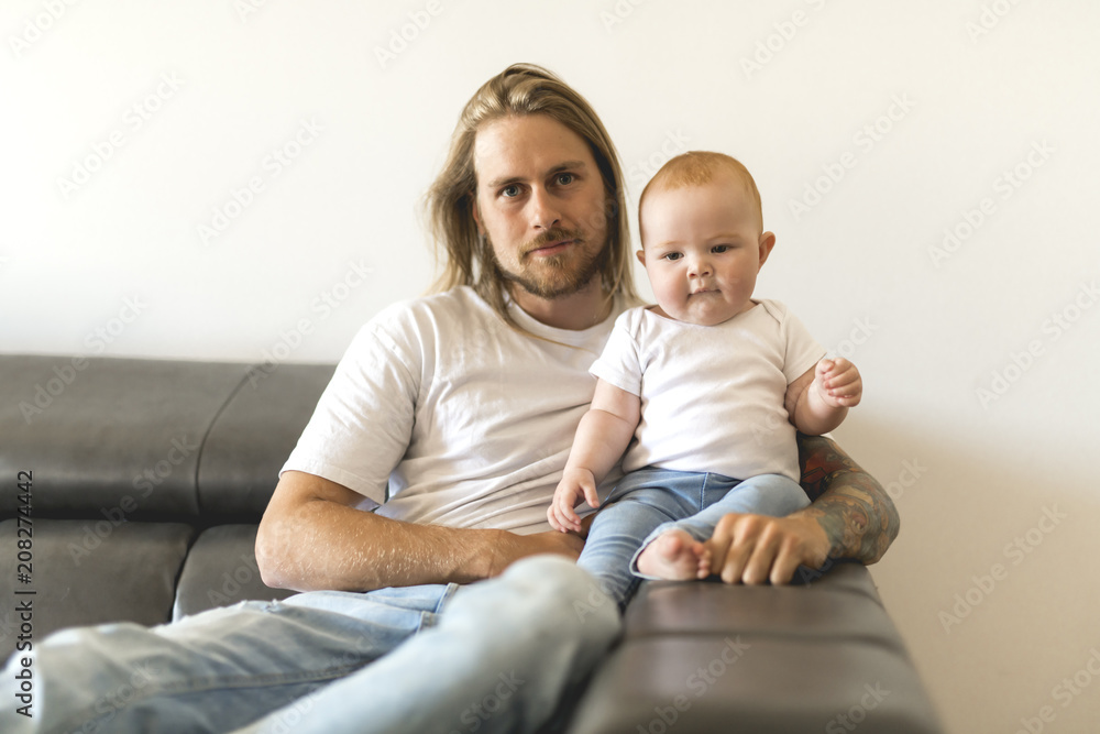 father playing with baby daughter on sofa at home father playing with baby daughter on sofa at home