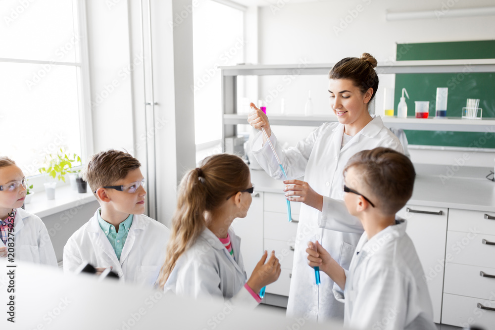 education, science and children concept - teacher and kids or students with test tubes studying chemistry at school laboratory education, science and children concept - teacher and kids or students with test tubes studying chemistry at school laboratory