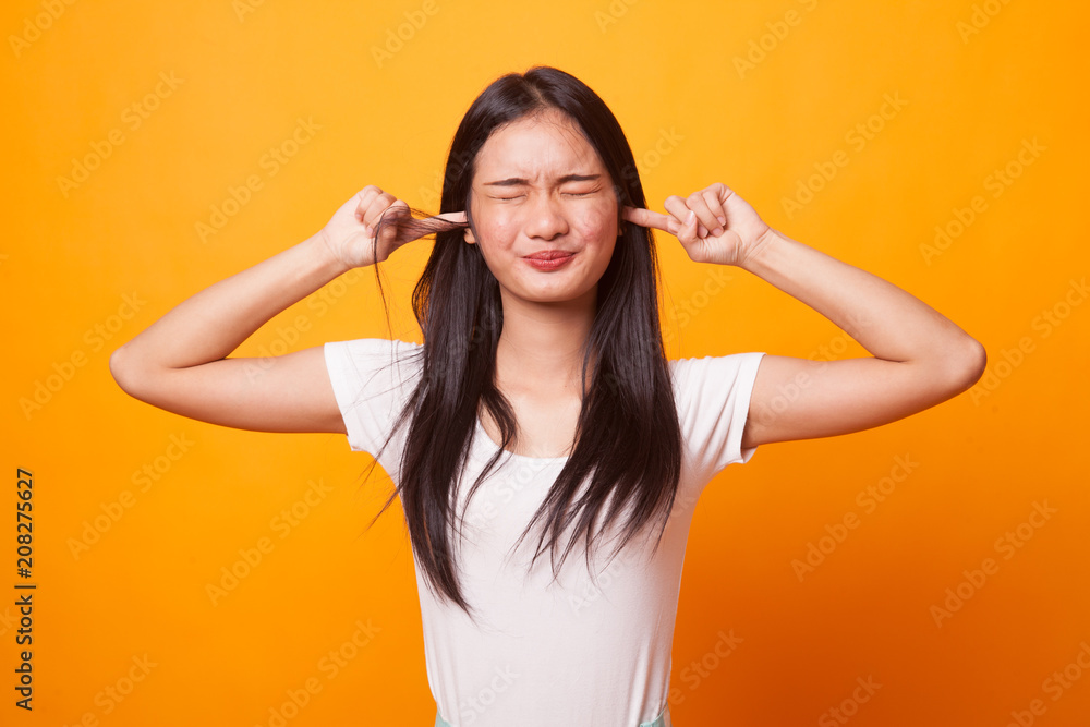 Young Asian woman block both ears with fingers. Young Asian woman block both ears with fingers.