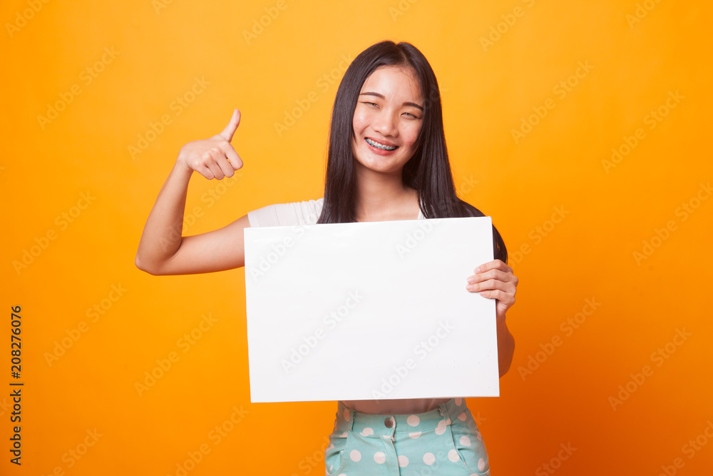Young Asian woman show thumbs up with white blank sign. Young Asian woman show thumbs up with white blank sign.