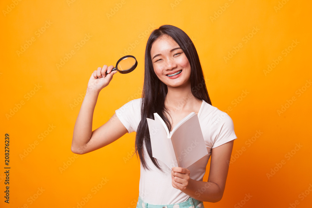 Asian woman with a book and magnifying glass. Asian woman with a book and magnifying glass.