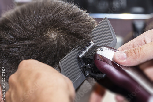 men's hair Styling and grooming with the help of scissors machine and hair clippers in the hair salon. photo