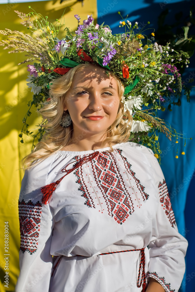 Beautiful  girl in national Ukrainian embroidery shirt and wreath of wild flowers. Holiday of Ivan Kupala in Ukraine.