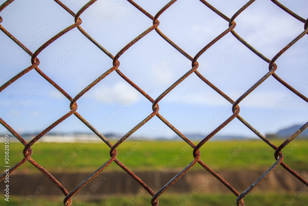 Naklejka premium Chain link fence with grass field Phuket International Airport