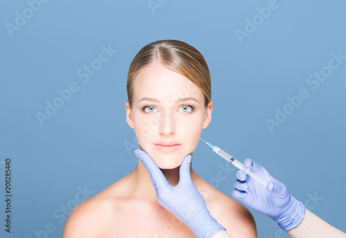 Young, beautiful and healthy woman having skin injections over magenta background.