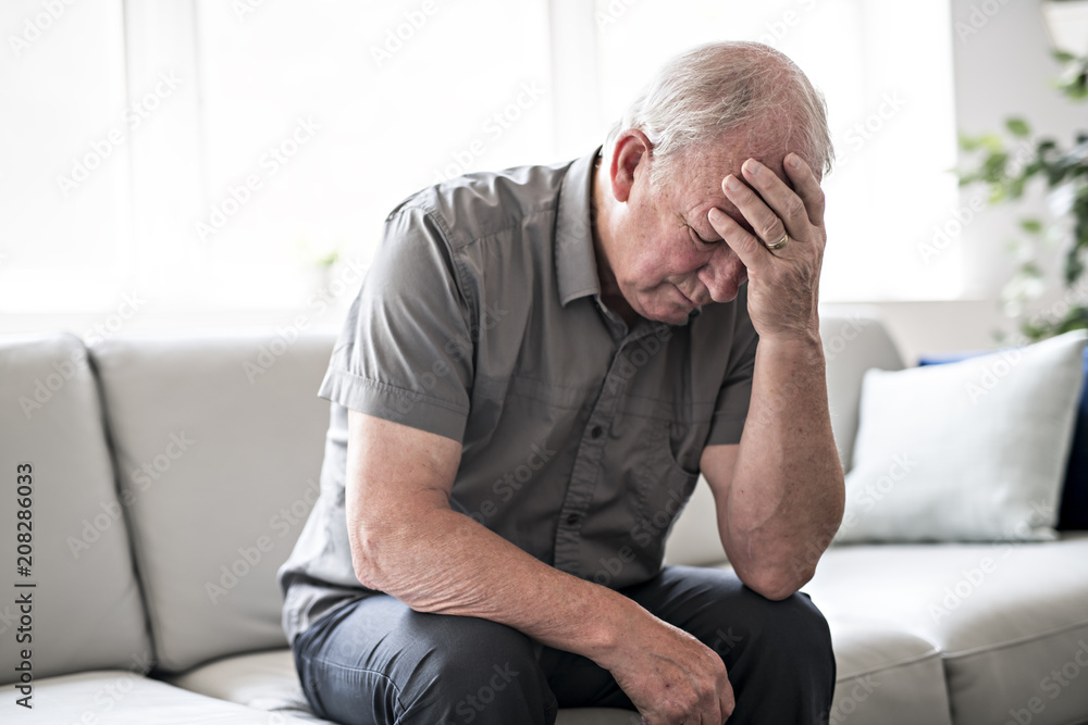 senior man thinking and sitting on sofa at home like sad senior man thinking and sitting on sofa at home like sad