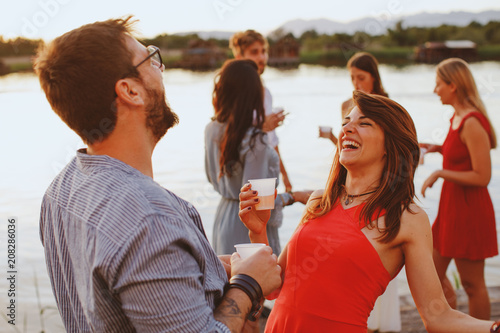 Man and woman flirting at party by the river