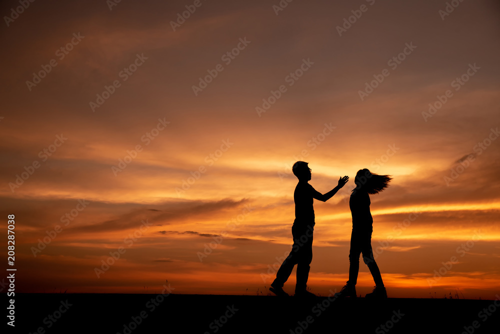Silhouette of anger of couples love who are quarreling (standing back to back),break up and have something problems with sunset background in Thailand.Anger,unhappy,bad relationship concept.