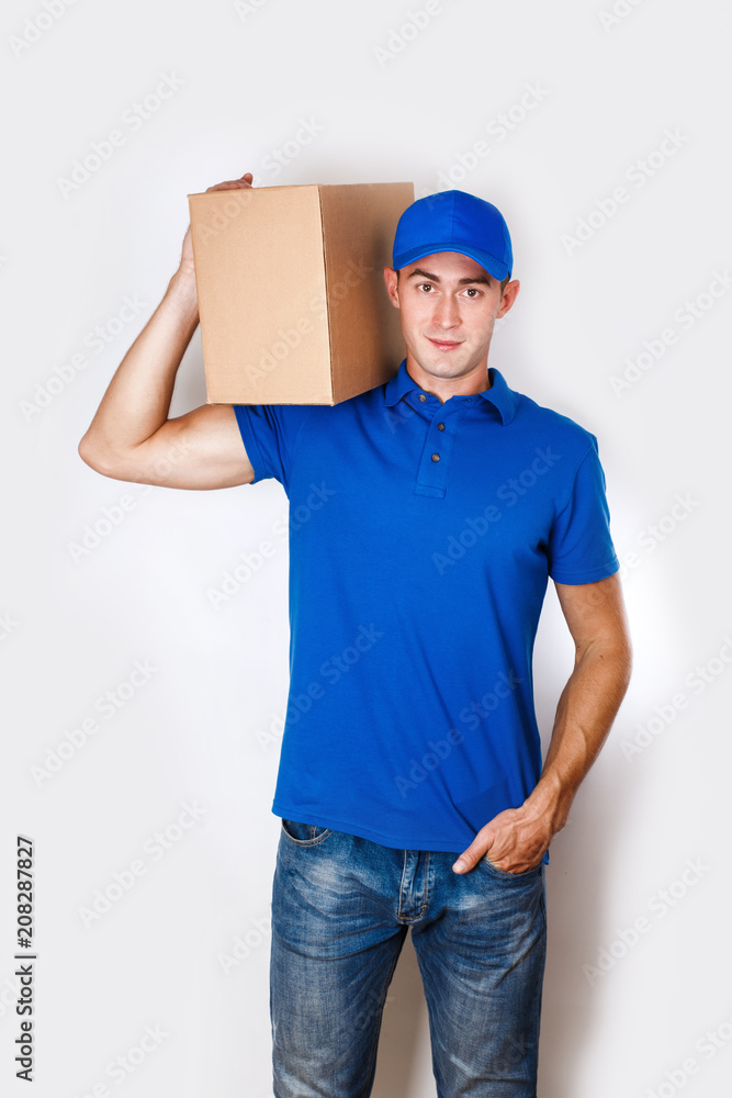 Cheerful delivery man. Happy young courier holding a cardboard box and smiling Cheerful delivery man. Happy young courier holding a cardboard box and smiling