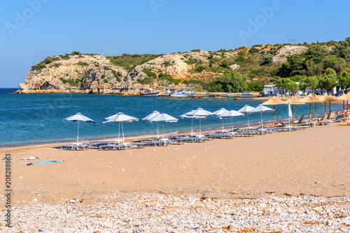 Fototapeta Naklejka Na Ścianę i Meble -  Sun loungers with umbrellas on sandy Kolymbia beach. Rhodes island, Greece