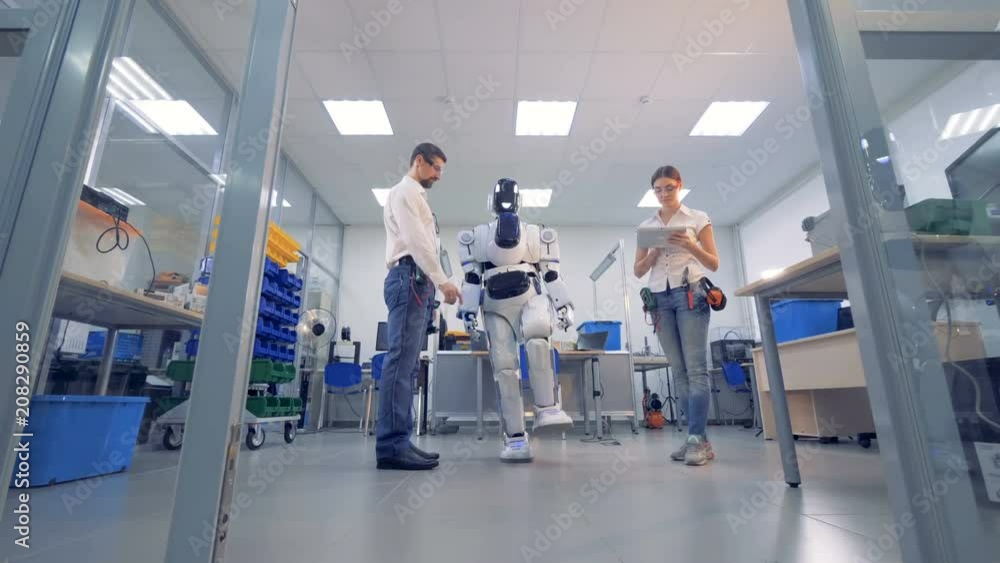 White robot copies movements of a man. White robot copies movements of a man.