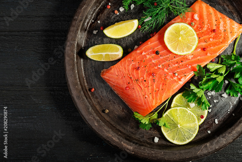 Fresh salmon fish fillet on black background, top view