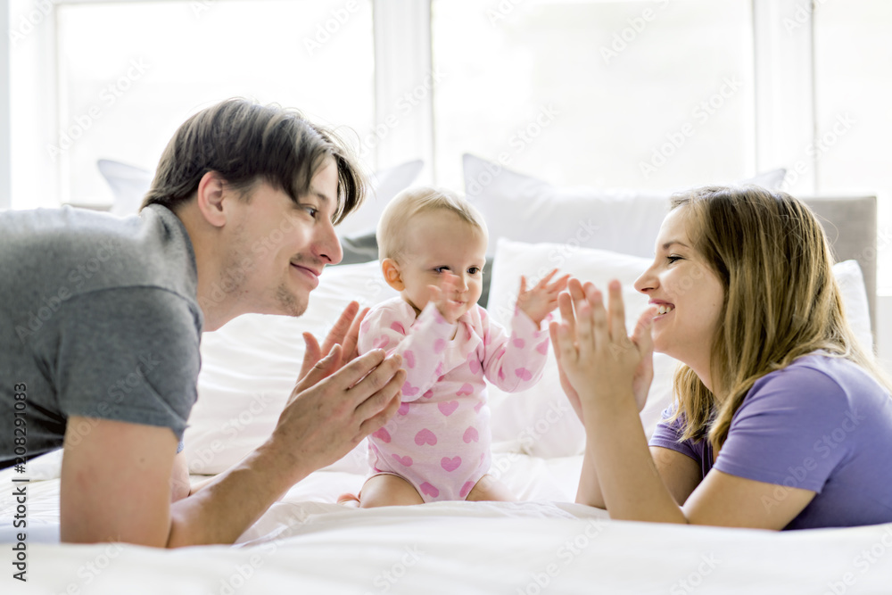 Portrait of beautiful young parents and cute baby on bed Portrait of beautiful young parents and cute baby on bed