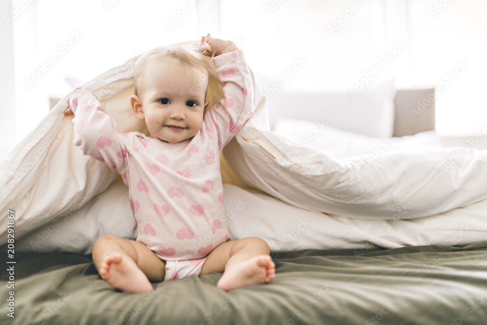Adorable baby girl cover with white sheet wearing pink clothes Adorable baby girl cover with white sheet wearing pink clothes