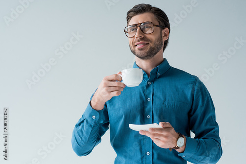 Cuadro en lienzo bottom view of happy young man with cup of coffee isolated on white