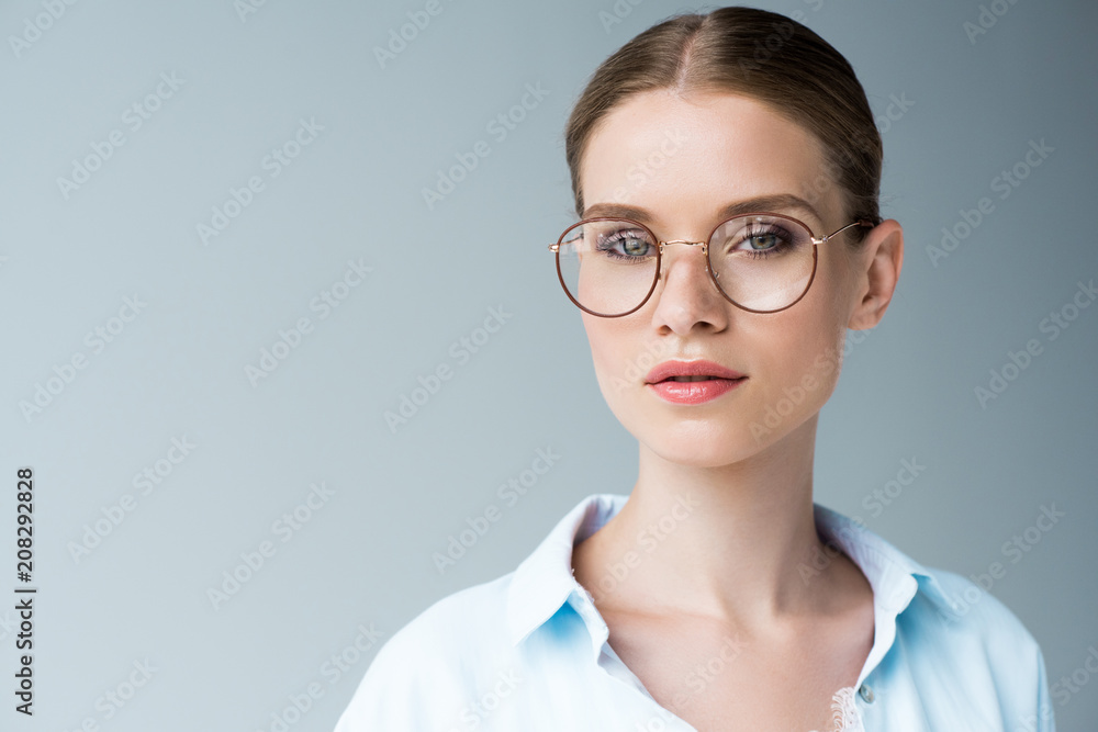 close-up portrait of beautiful young woman in stylish sunglasses isolated on grey
