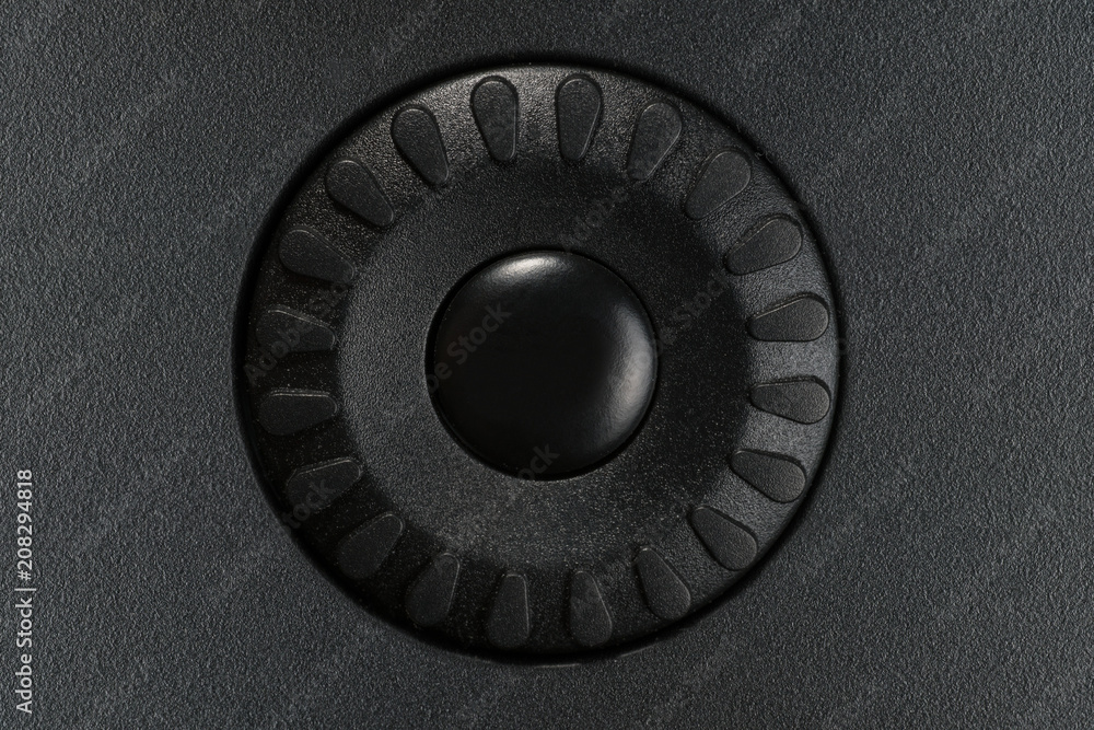 Black control wheel on black plastic panel Black control wheel on black plastic panel