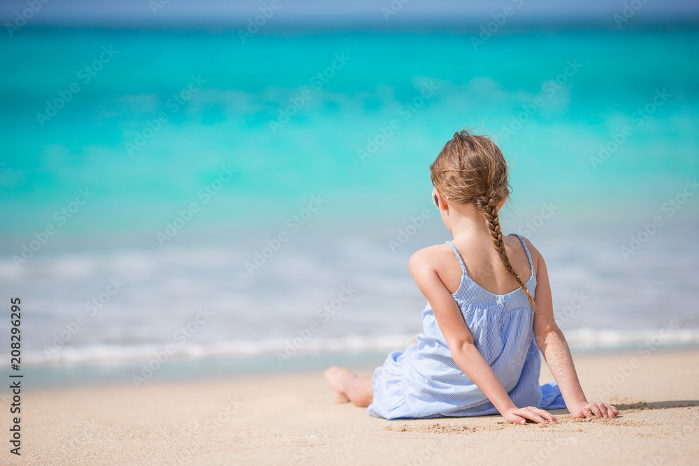 Beautiful little girl in dress at beach having fun.