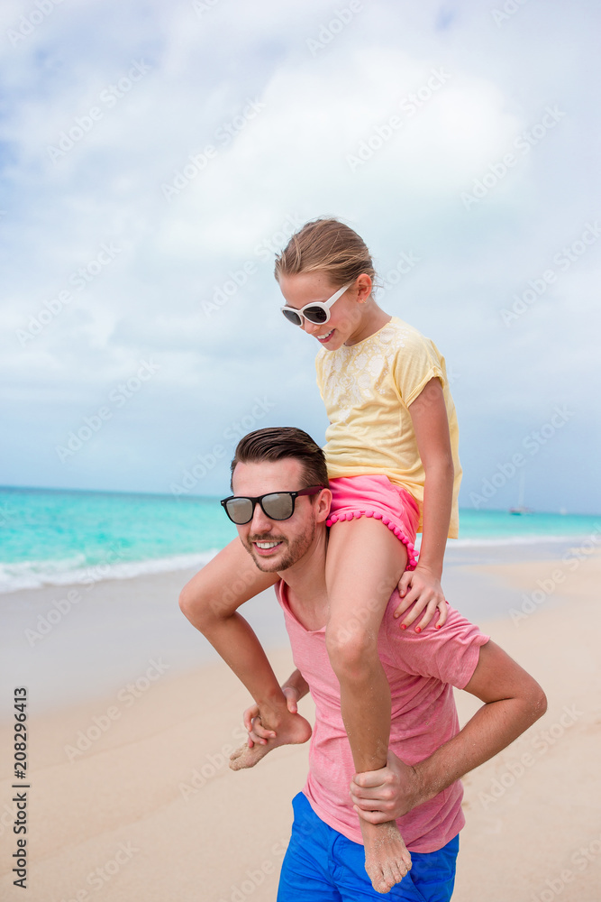 Family of father and sporty little girl having fun on the beach Family of father and sporty little girl having fun on the beach