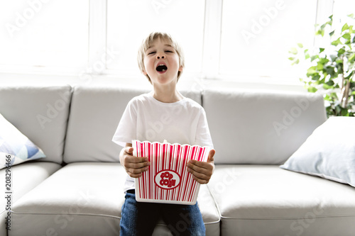 adorable child Watching TV in his home with popcorn