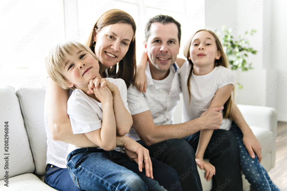 Family of four having fun on the sofa at home