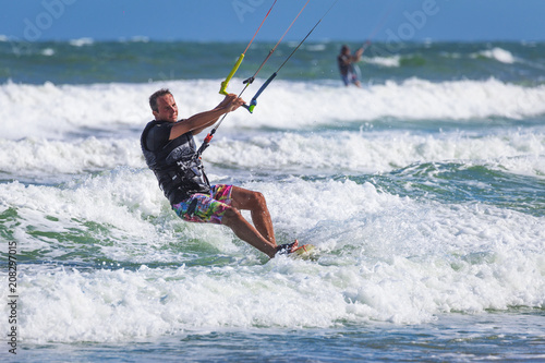 Young athletic man riding kite surf on a sea