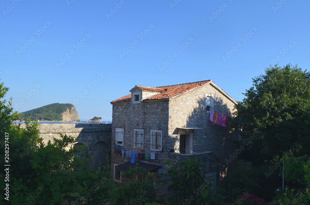Fototapeta premium Laundry hanging out to dry on a stone house surrounded by trees