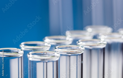 Glass test tubes on blue background in laboratory.